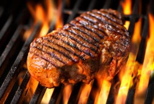 steak being cooked on a grill - a source of saturated fat