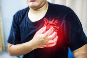 man clutching his chest during a heart attack