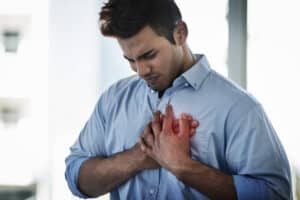 man experiencing symptoms of cardiac arrest