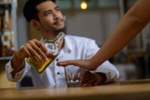 man being prevented from pouring a drink - heart healthy thinking