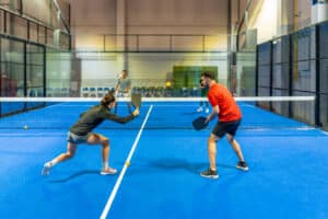 4 young adults playing pickleball on an indoor court