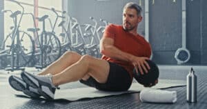 middle aged man using a medicine ball during his workout in the gym to reduce his risk of stroke