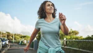 senior woman walking outside to resume exercise after a heart attack