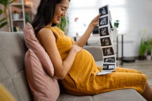woman concerned about a heart healthy pregnancy checking her ultrasound results in her living room